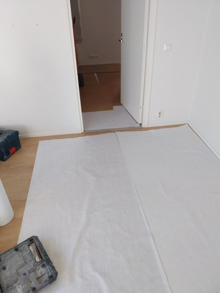 Asuinhuoneiston lattian suojaus remontin edetessä.